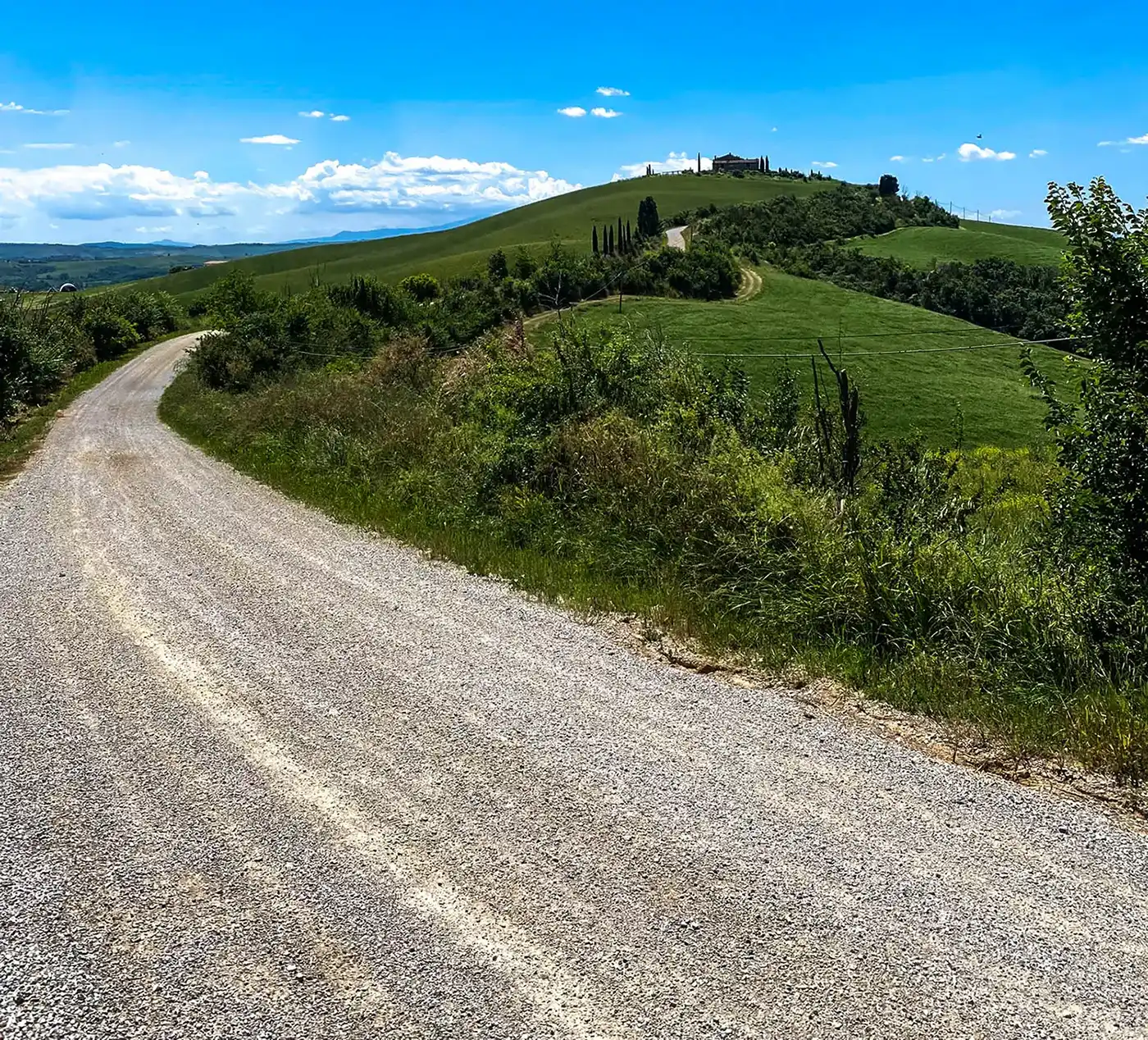 road with a hill in the distance and a blue sky